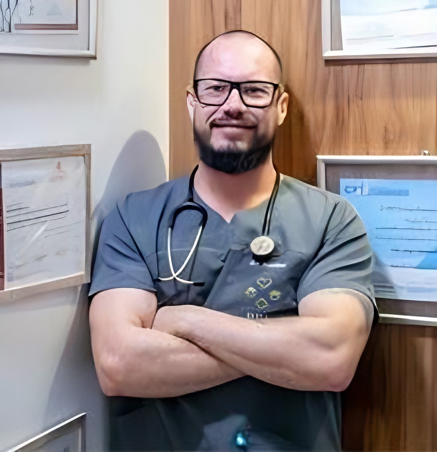 Médico de braços cruzados em seu consultório